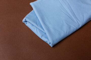 Fototapeta premium blue knitted fabric on a brown background