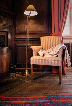 Elegant Ladies Coat Draped Ove The Arm Of A Chair In A Period Wooden Panelled Drawing Room