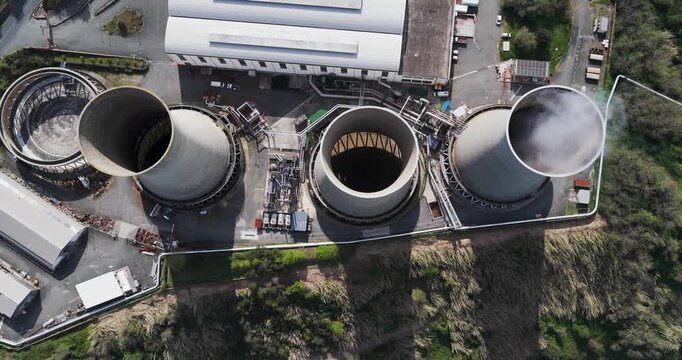 Larderello, Italy - 15 April 2026: Aerial view of Enel Green Power geothermal power plant with massive cooling towers, industrial buildings, and steam emissions in the Tuscan landscape.