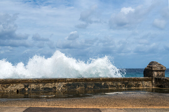 Cuba, Havana, The Malec&oacute;n.  Waves crash on the wall protecting the famous Avenida de Maceo, pedestrian walkway on the harbour.