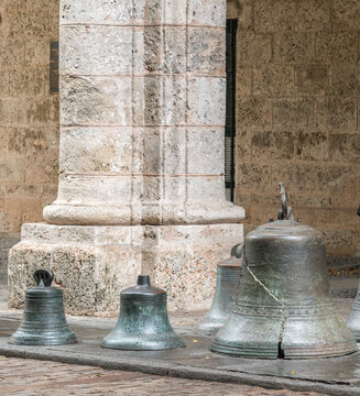 Cuba, Havana, A collection of old damaged bells in front of the Palacio de los Capitanes Generales, now the home to the Museum of the City of Havana.  Close by the Plaza de Armes.