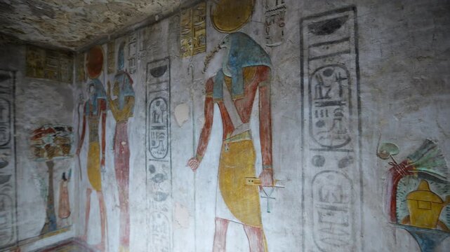 KV14 royal tomb, Valley of the Kings, Luxor, Egypt, with vivid Egyptian gods, winged goddess Isis, pharaoh figures, hieroglyphics on golden yellow walls.