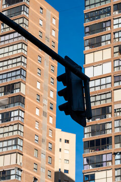 Highrise building architecture towers over a blue urban street with traffic signal in Benidorm Spain contemporary metropolitan perspective