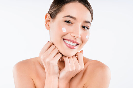 Young woman applying moisturizing cream on skin isolated on white background, beauty portrait, skincare treatment, hydration, moisturizing and wellness routine