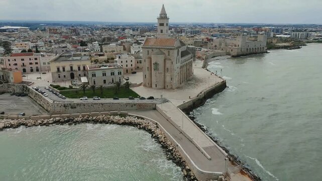 Aerial view of the Trani Cathedral (Cattedrale di Trani, Cattedrale di San Nicola Pellegrino) in Puglia in Italy dedicated to Saint Nicholas the Pilgrim, drone pulling away and circling