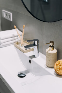 Modern bathroom sink with chrome faucet and eco-friendly toothbrush
