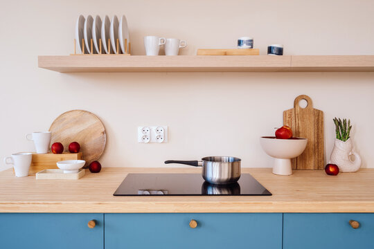 Kitchen interior featuring induction hob, wood counter, blue cabinet