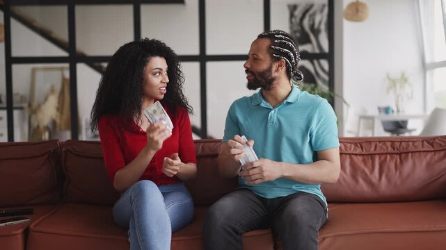 Happy African American couple counting money and celebrating business success