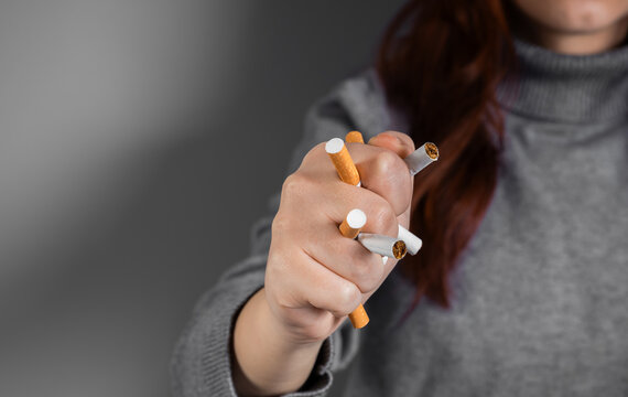 Conceptual image of quitting smoking by crushing a cigarette in a clenched fist, symbolizing strength, determination, breaking addiction, and commitment to a smoke-free lifestyle.