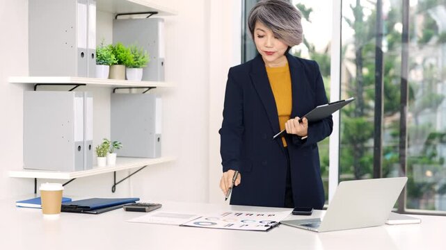 Business woman working in office checking documents.Accounting manager executive  reading paper file financial report, tax invoice.