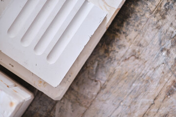Close up of white moulded plaster decorative trim with stepped profile on wooden surface for interior design and construction detail. Manufacture and construction © dannyburn
