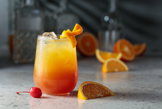 Cocktail Tequila sunrise with ice, orange juice, grenadine, and silver tequila.