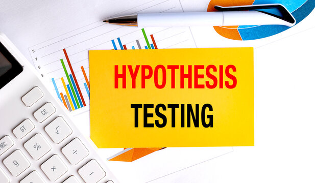 Hypothesis testing text on yellow paper with calculator pen and financial charts on desk data analysis concept