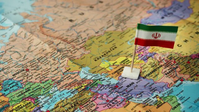 Person places Iranian flag on map highlighting country in Middle East.