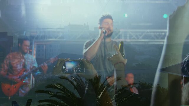 Vertical video: Vocalist singing concert while lights cueing fans raising phones, overlaying singer
