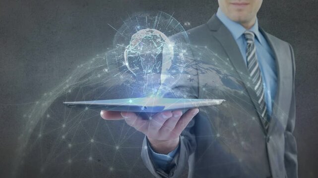 Vertical video: Male exec tapping tablet, projecting hologram globe with network nodes for business