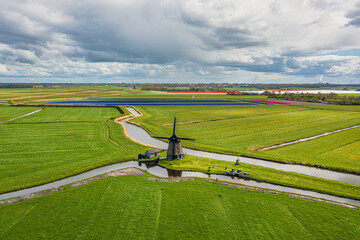 A bird's-eye view of a landscape in North Holland with a typical windmill. © fotografci