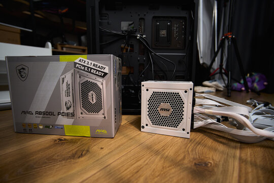 Tyumen, Russia-February 15, 2026: MSI power supply unit is shown on a wooden surface as part of the assembly of a personal computer
