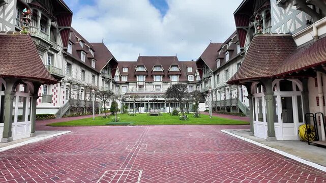 Push-in shot through circular wall openings revealing the courtyard of a traditional half-timbered building.