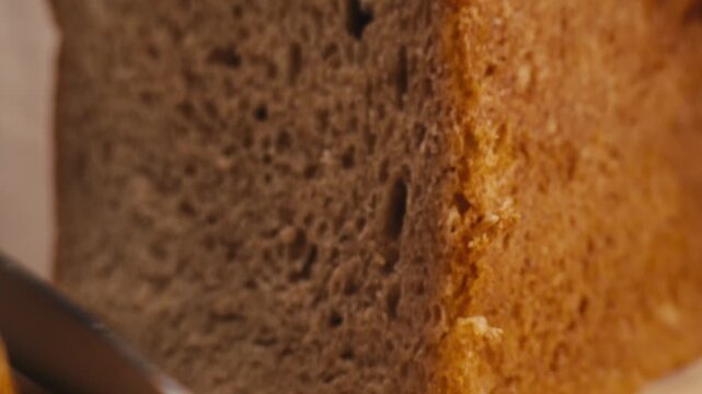 Black rye bread close up, dark brown sliced loaf, borodinsky slavic food, square slices with coriander on white background