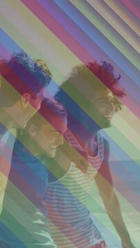 Vertical video: Cam starting tracking rainbow overlay urging four friends walking laughing bonding