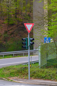 Traffic signal and yield sign at a road intersection with a bridge overhead