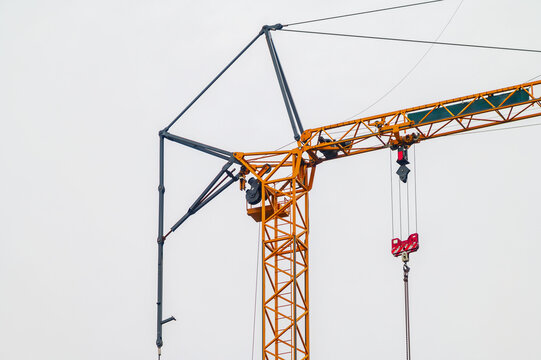 Towering yellow construction crane against a pale sky, ready for work