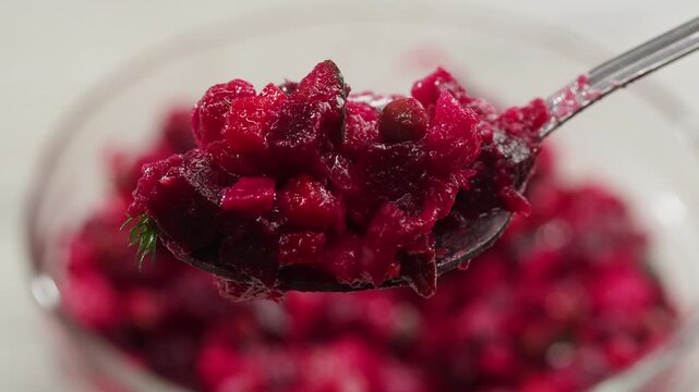 Russian beetroot vinaigrette salad with green peas, boiled vegetables and dill, close up in restaurant. 