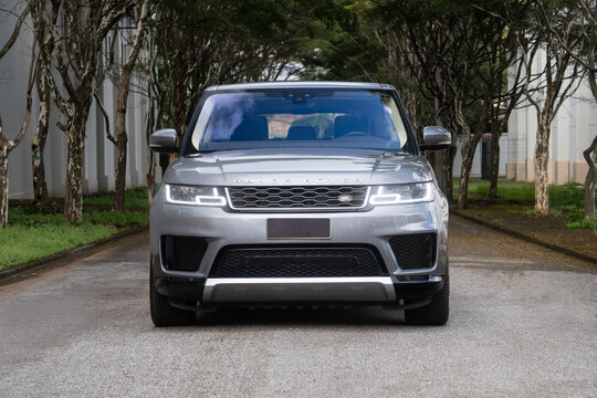 Gray range rover sport front view outdoors, Luxury SUV on tree lined road