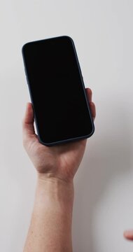 Vertical video: Left hand holding phone on white right hand entering and tapping screen to wake