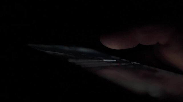Man Scrolling Social Media on Smartphone at Night