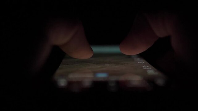 Man Scrolling Social Media on Smartphone at Night