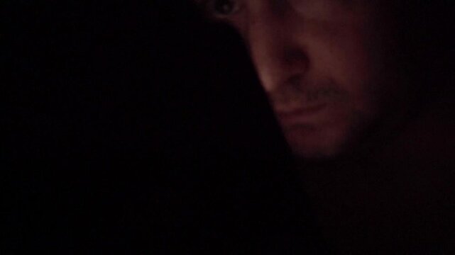 Man Scrolling Social Media on Smartphone at Night