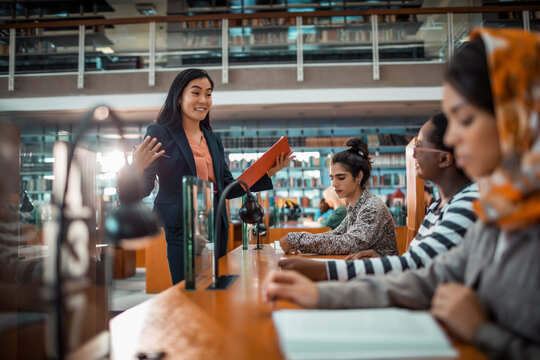 Teacher guiding students during study session in university library