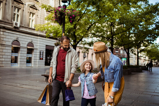 Happy family shopping together on city street