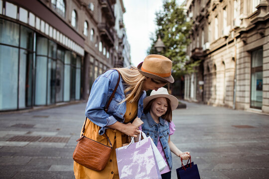 Mother and daughter shopping on city street