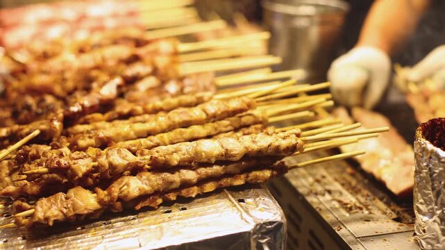 Korean barbecue, Ddakkochi, grilled chicken and pork skewers, variety of different traditional street food selection in Seoul, South Korea, night market with local vendor stalls cooking tasty dishes
