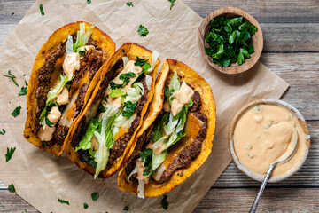 Top down view of smash burger tacos with fresh toppings, ready for eating. © Carey