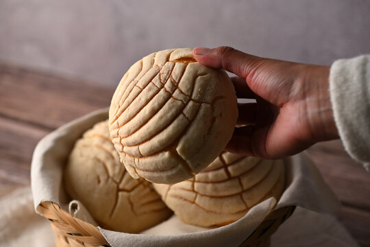 A woman's hand holding a vanilla shell in her hand. Food photography low key