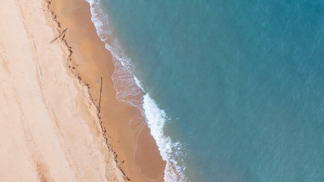Tropical beach landscape from drone perspective showing turquoise sea and smooth sand coastline. Minimal natural background ideal for travel websites, resort promotions, and summer design projects.