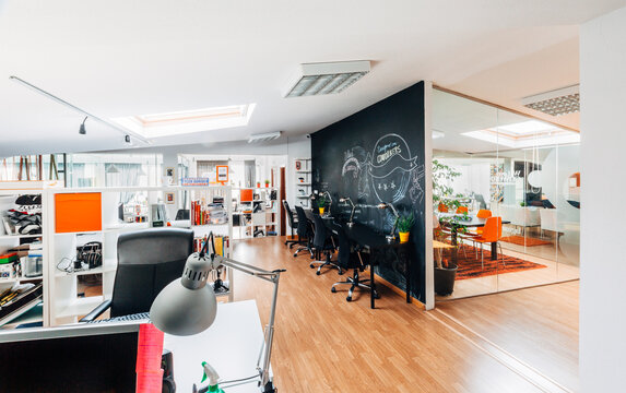 Modern open plan office with chalkboard wall and meeting room