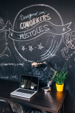 Modern workspace with laptop and chalkboard coffee message