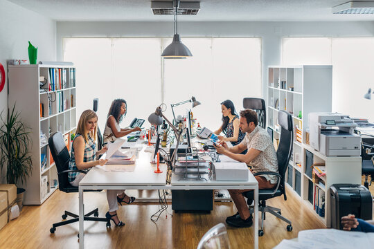 Modern open office team working at shared desks