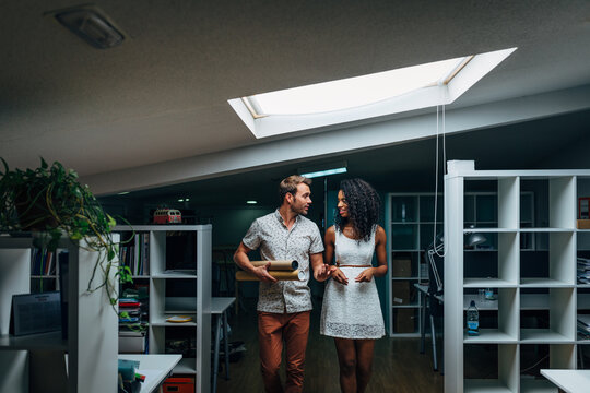 Couple touring modern loft apartment with skylight