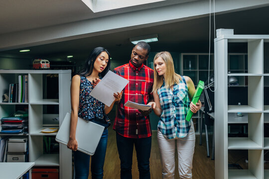 Diverse colleagues reviewing documents together in modern office