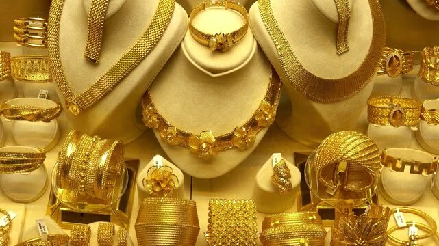 Luxury gold jewelry necklaces and bracelets displayed in shop window for sale
