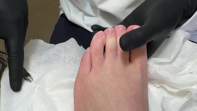Pedicure podology salon beauty foot care cuticle procedure by specialist shows treatment with nippers on toes during a professional hygienic session.
