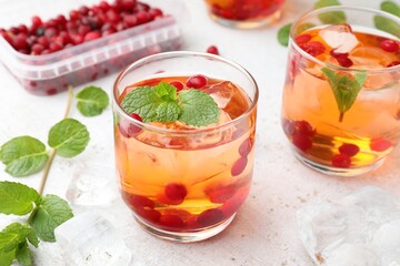 Obraz premium Refreshing cocktails with cranberries and mint on light table, closeup