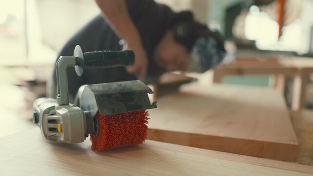 Woodworker sanding a wooden plank with a power sander
