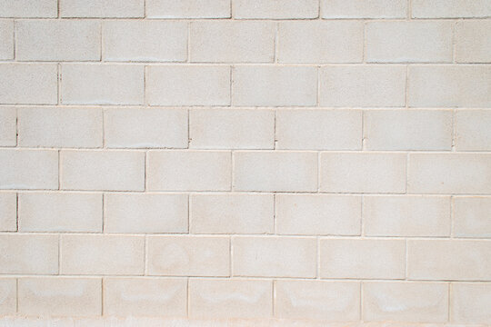 Pared de bloques de hormig&oacute;n gris claro con textura uniforme.